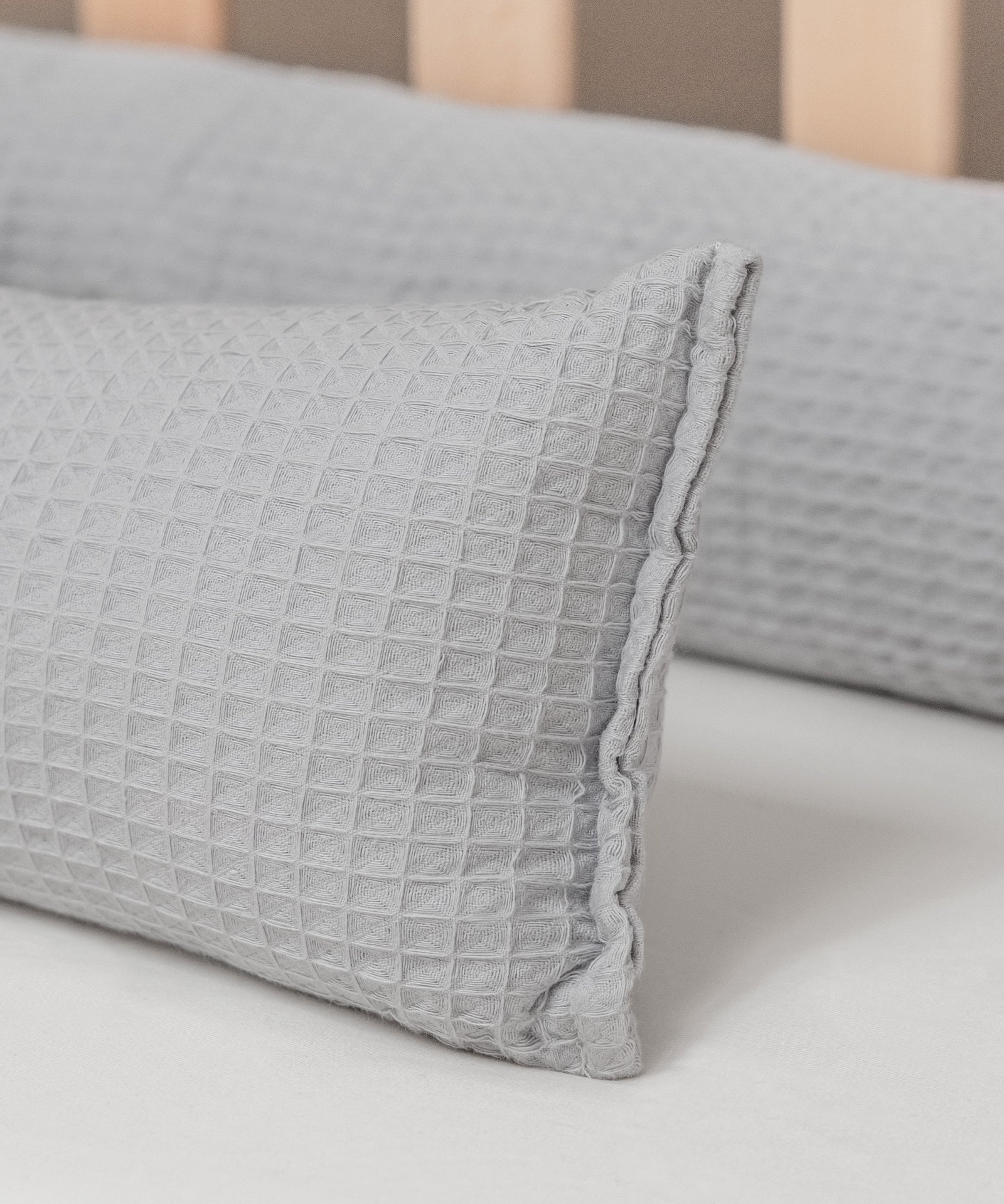 Natürlich & hochwertig*Der weiche Waffelpiqué besteht aus reiner Bio-Baumwolle und ist somit besonders kuschelig und sanft zur Haut deines Babys.|Detailaufnahme Bettschlange aus Waffelpiqué in hellgrau.
