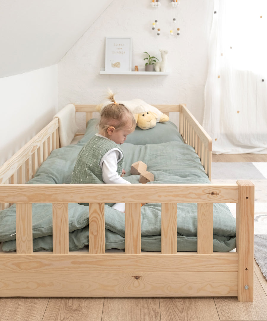 Mädchen spielt in Baby und Kinder Bodenbett.