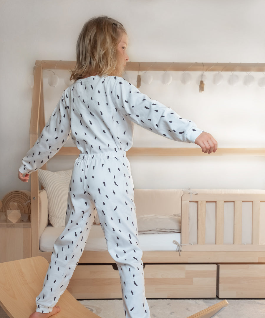 Interlock*Der sehr feine, glatte und dehnbare Maschenstoff ist bequem und kuschelig weich zur Kinderhaut.|Mädchen in Pyjama aus Interlock weiß-schwarz.