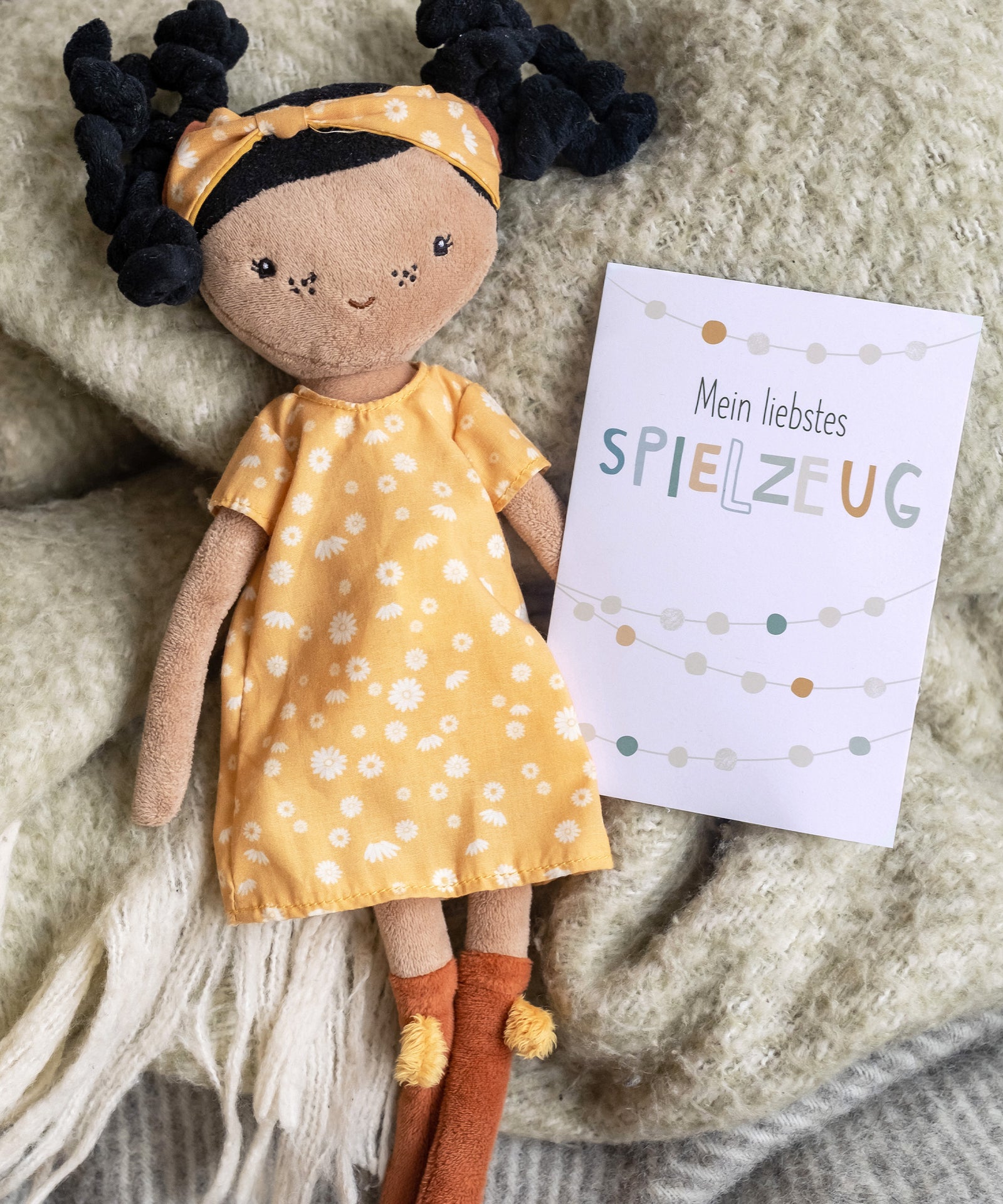 Nachhaltig gedruckt*Die Karten werden klimaneutral mit mineralölfreien Bio-Farben auf stabilem, zertifiziertem Recyclingpapier gedruckt.|Karte mit Aufschrift „Mein liebstes Spielzeug“ liegt neben einer Puppe.