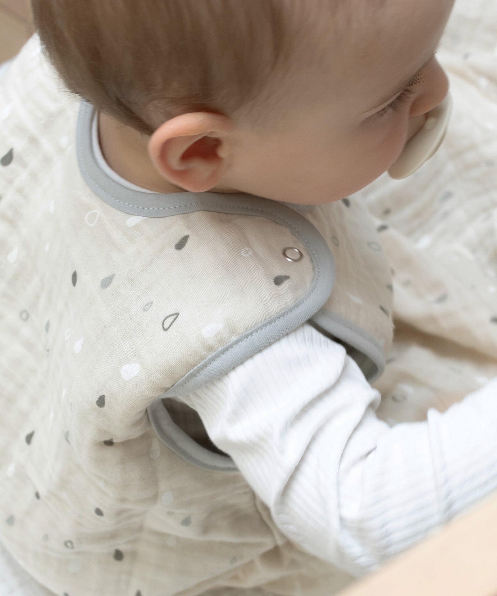 Praktische Druckknöpfe*Dank der Druckknöpfe ist der Schlafsack schnell angezogen, ohne ihn über den Kopf ziehen zu müssen - unkompliziert und stressfrei!|Nahaufnahme der Druckknöpfe am Babyschlafsack aus Musselin.
