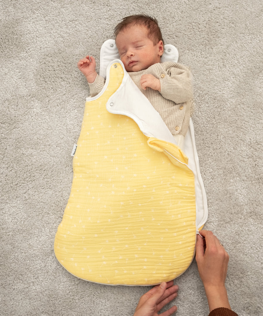 Baby schläft im Musselin Babyschlafsack. Der Reißverschluss wird ganz leicht geöffnet.