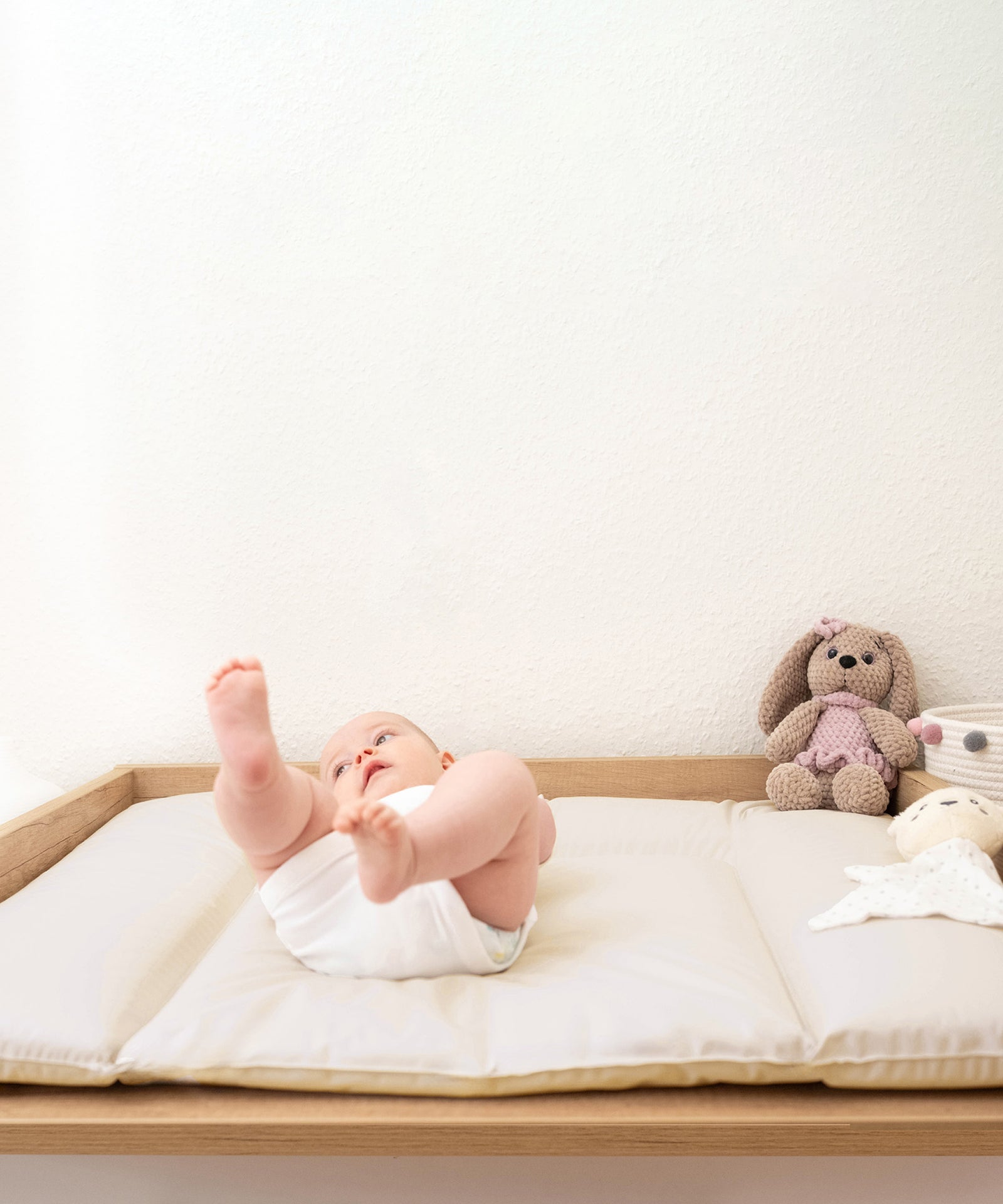 Baby liegt auf der Wickelauflage
