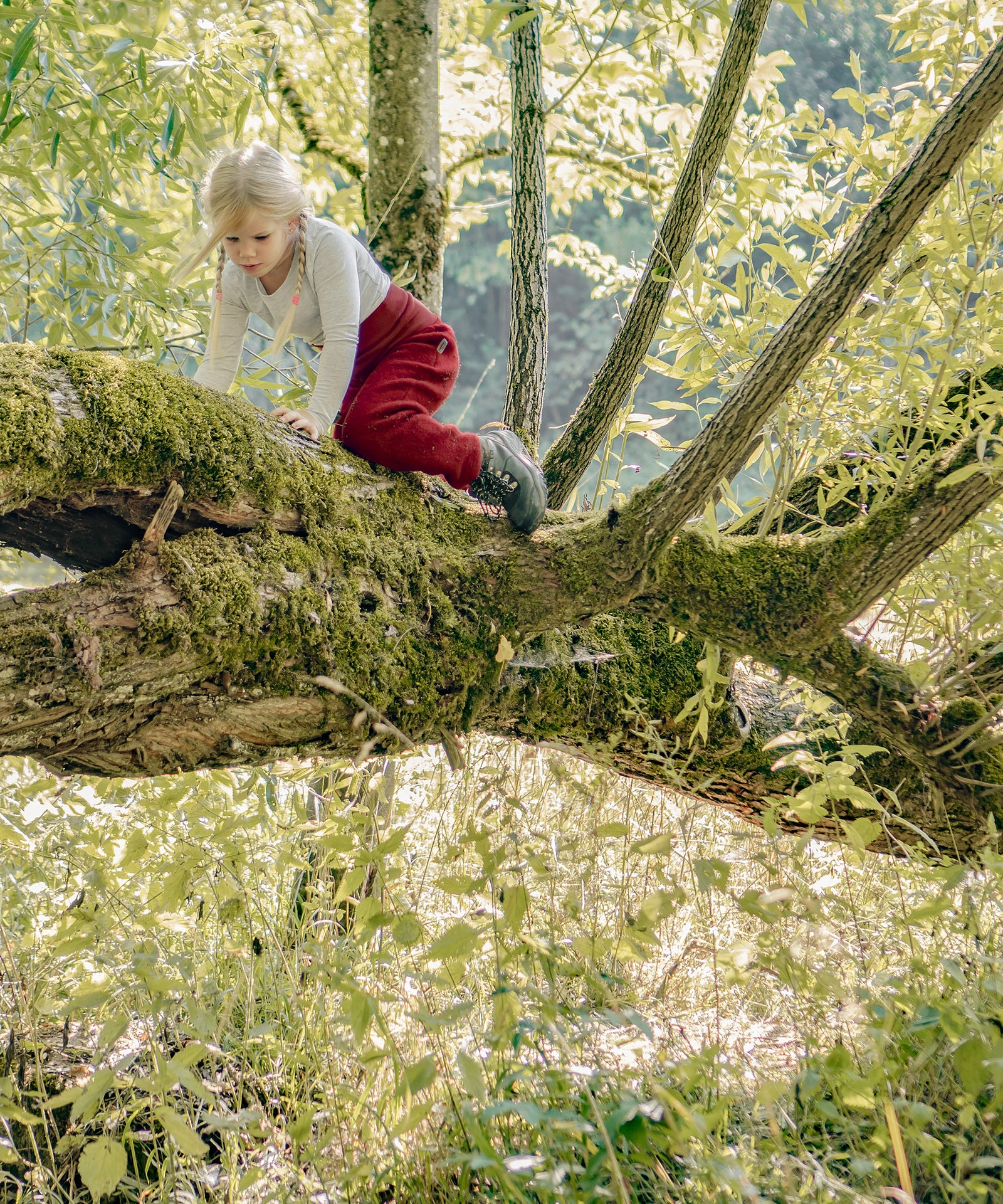Reinschlüpfen & los geht’s*Dein Kind wird auch mit mehreren Lagen darunter in seiner Bewegungsfreiheit nicht eingeschränkt - perfekt zum Klettern und Toben.|Kind klettert auf einem Baum.