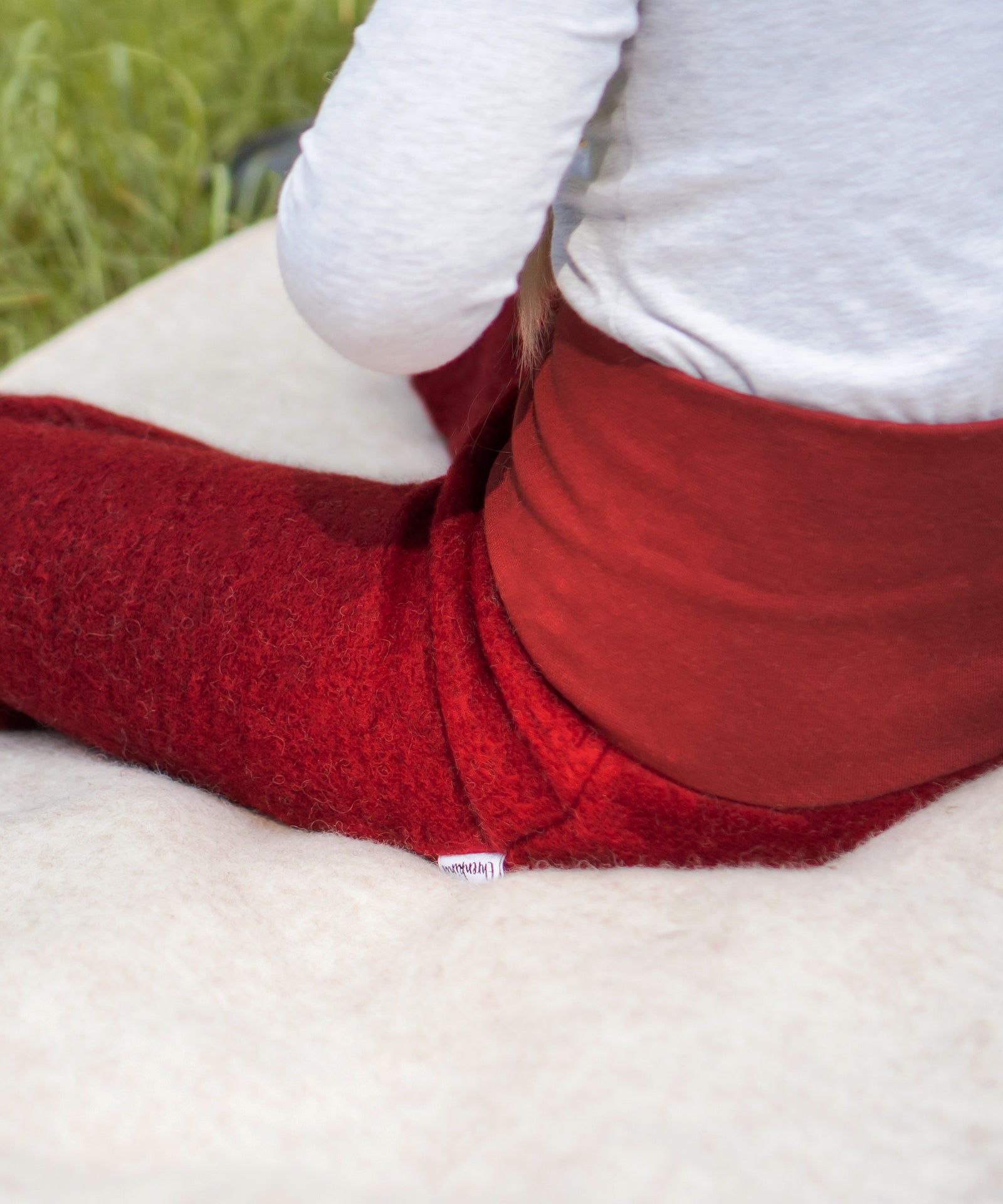 Kuschelig & warm*Die Walkhose aus Schurwolle ist wärmeregulierend und kuschelig weich. Der hohe Bund sorgt für einen perfekten Sitz beim Spielen.|Kind sitzt auf einer Walkdecke. Nahaufnahme der Walkhose.