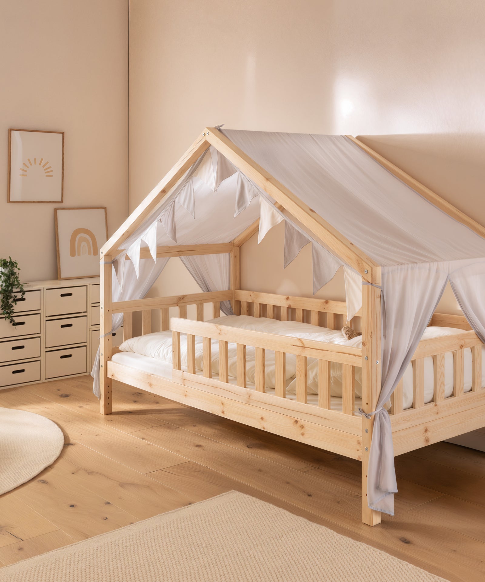 Ein geschützter Platz im Bett*Der Betthimmel greift die Hausform auf und schafft einen Platz zum Lesen, Entspannen und Spielen.|Das Panorama Hausbett mit dem Betthimmel-Set in Hellgrau.