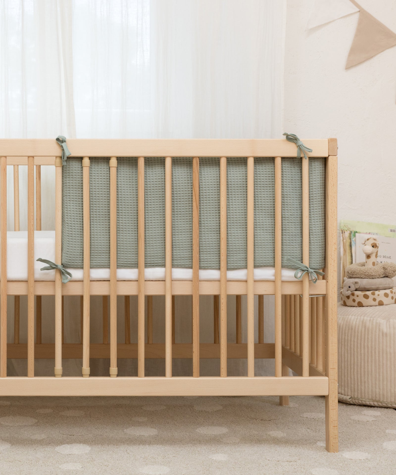 Einfache Anbringung*Mittels Befestigungsschnüren kann die Bettumrandung gleichmäßig an den Streben befestigt werden.|Bettumrandung wird mit Befestigungsschnüren sicher am Babybett angebracht.