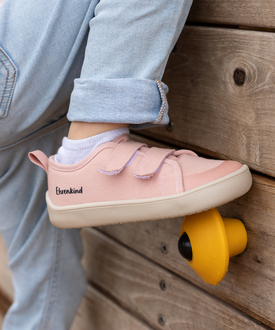 Viel Bewegungsfreiheit*Die Barfußschuhe folgen der natürlichen Bewegung beim Spielen und Toben und unterstützen so die kindliche Fußentwicklung.| Kind trägt beim Klettern die Barfußschuhe in Rosé.