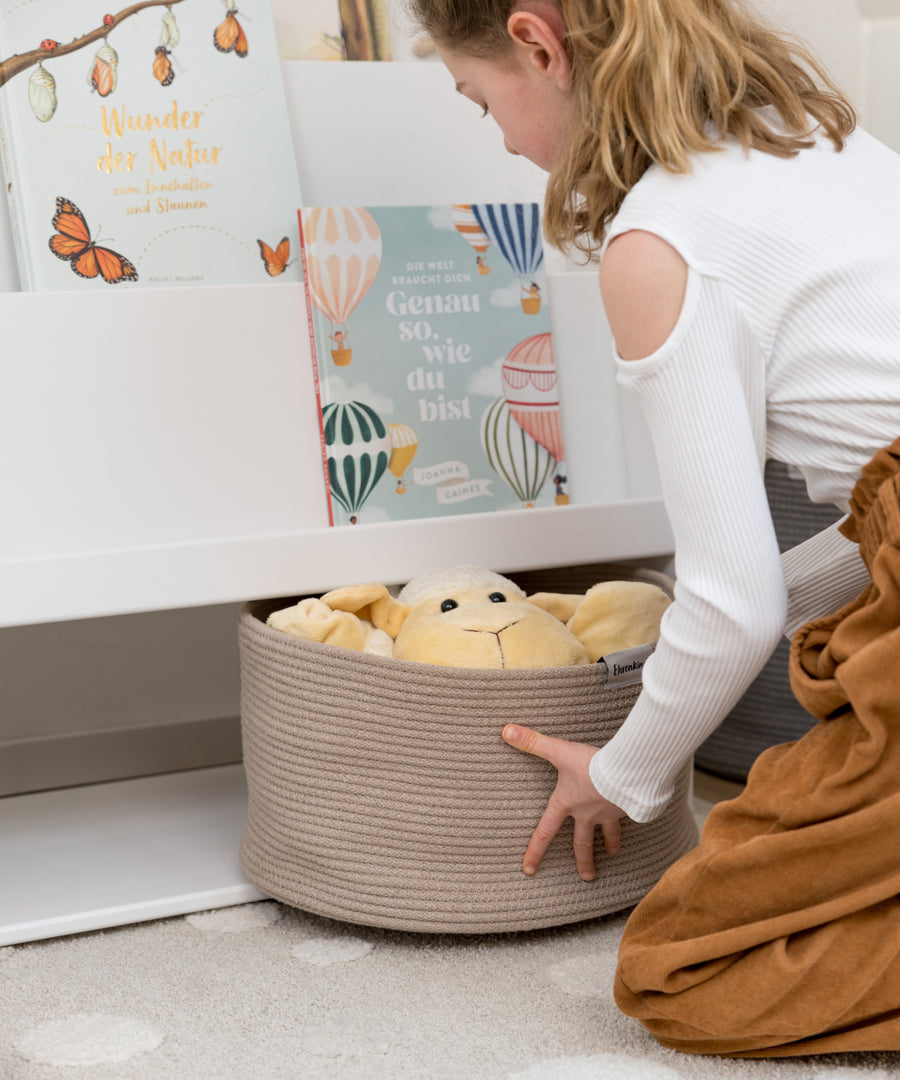 Alles auf Kinderhöhe*Alle Fächer sind für Kinder leicht erreichbar. Das fördert die Eigenständigkeit und macht Aufräumen kinderleicht.|Kind räumt selbstständig die Aufbewahrungskörbe in das Regal.