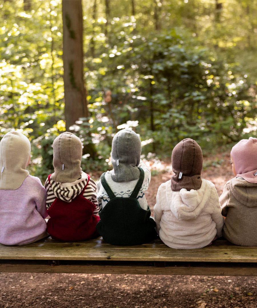 100% nachhaltige Bio-Schurwolle*Die hochwertige, feine Merinowolle stammt aus kontrolliert biologischer Tierhaltung und ist mulesingfrei.|Kinder tragen die Schlupfmützen in verschiedenen Farben.