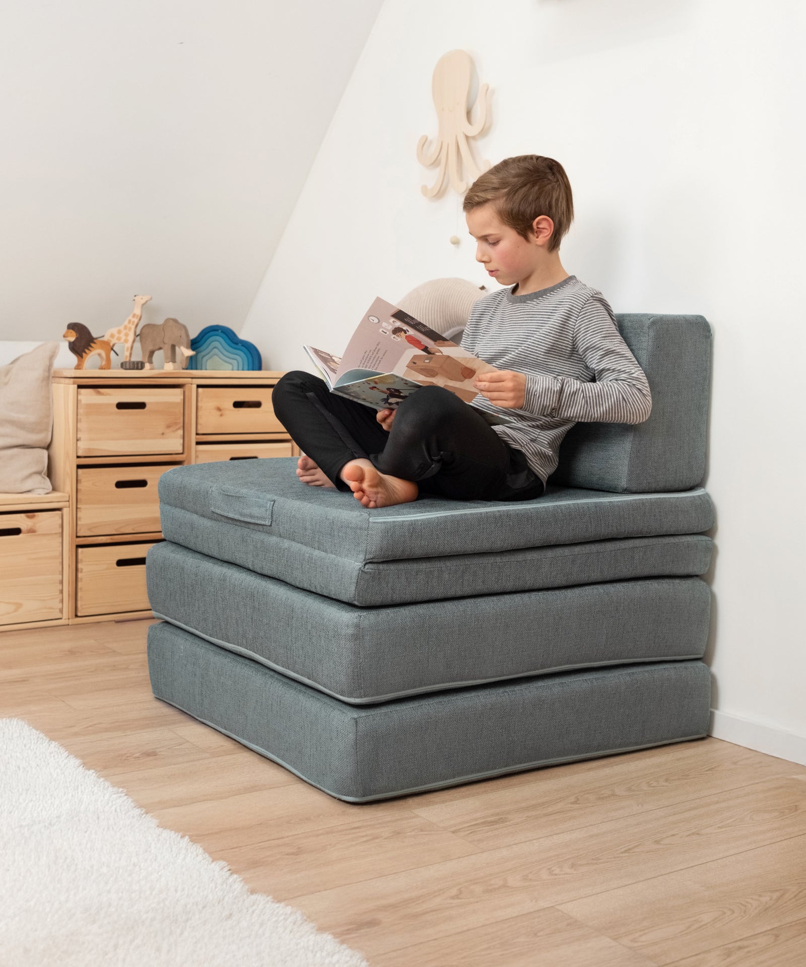 Das Spielsofa kann zu einem erhöhten Stuhl zusammengeklappt werden.