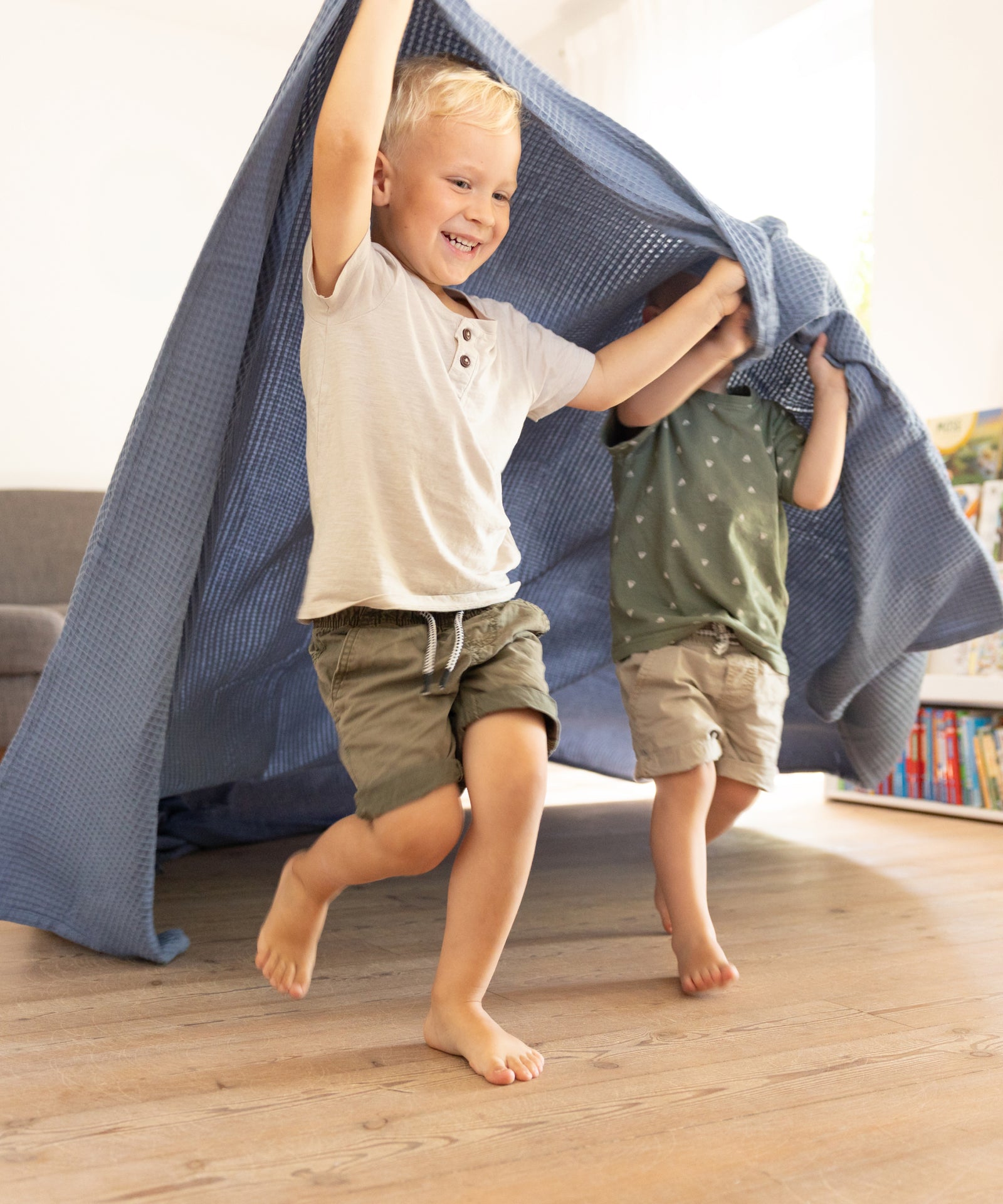 Kinder spielen mit Tagesdecke.