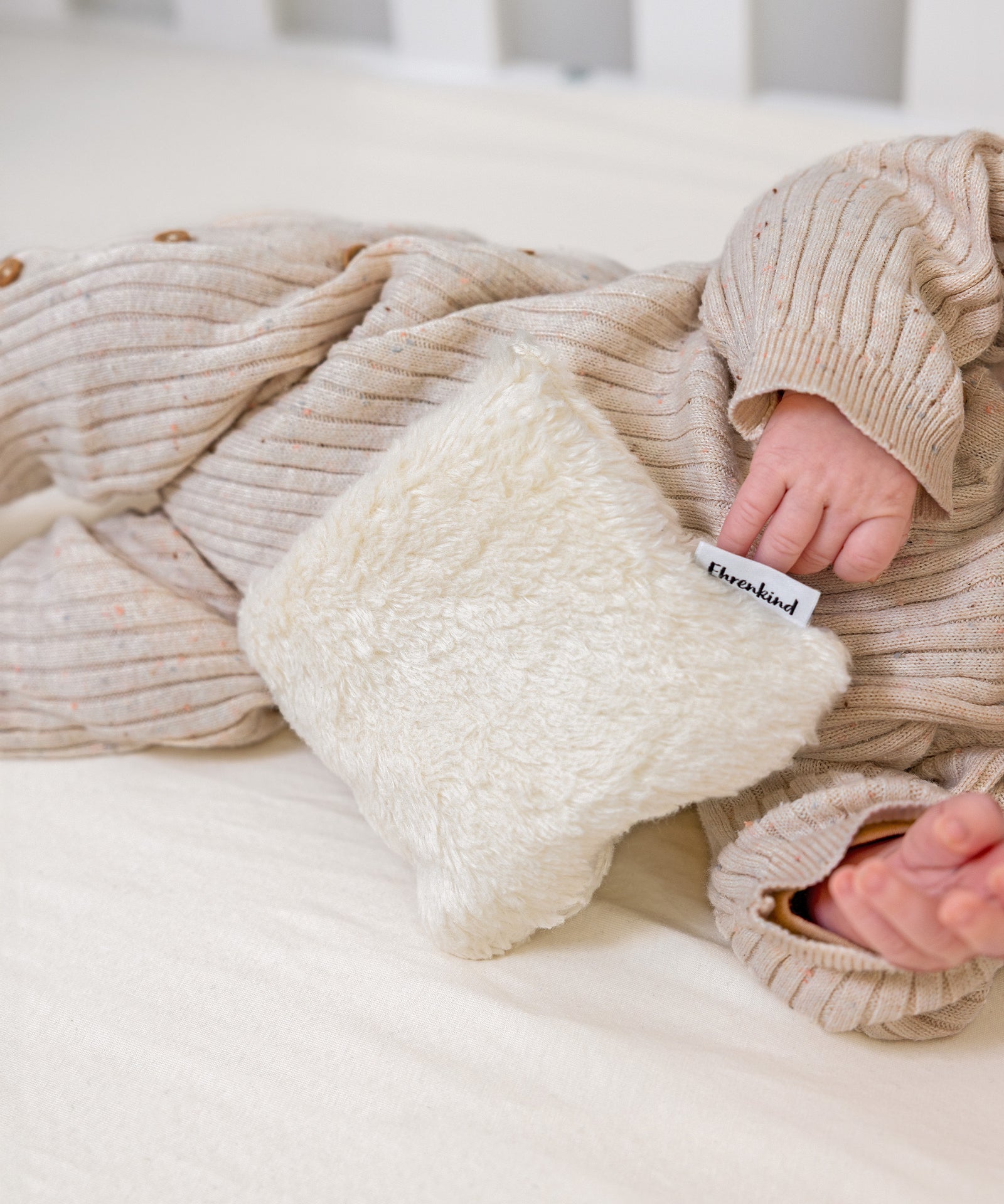 Wohltuende Wärme*Das Wärmekissen mit Kirschkernfüllung spendet angenehme Wärme und sorgt für wohltuende Kuschelmomente bei Babys und Kindern.| Wäremkissen liegt mit dem Baby im Bett.