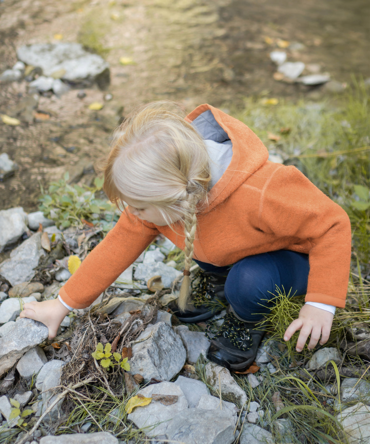 Natürlich wärmend & wetterfest*Der Walkstoff verfügt über sehr gute Wärmeeigenschaften und ist von Natur aus schmutz- und wasserabweisend. Walkjacke in Apricot.|Kind spielt in der Natur und trägt die Walkjacke in Apricot.