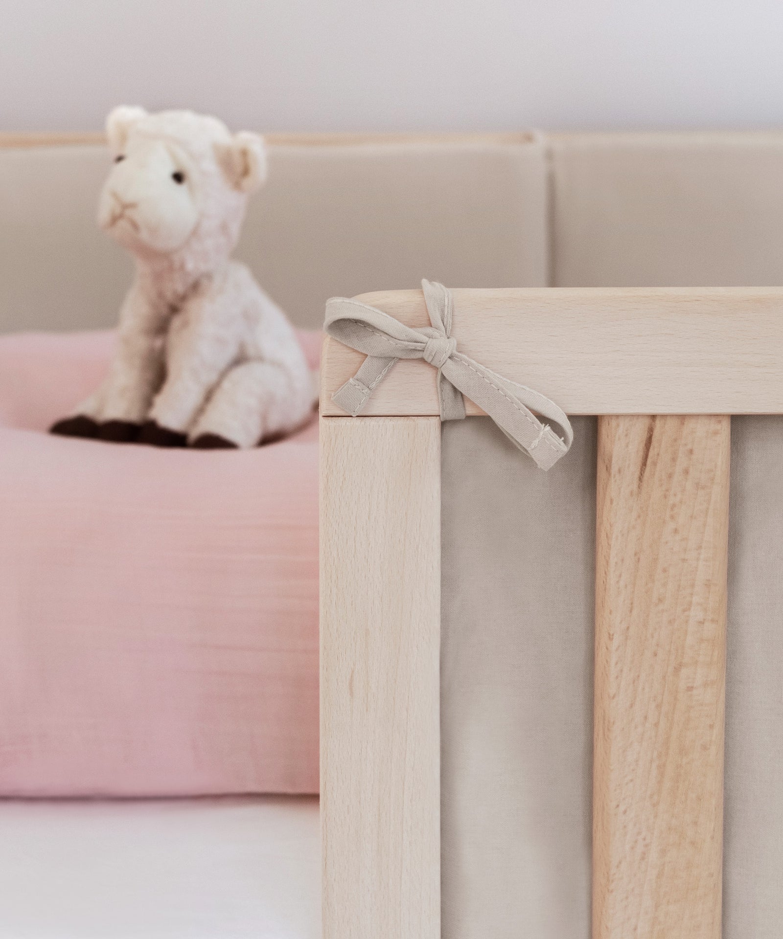 So praktisch*Mittels Befestigungsschnüren kann die 4-teilige Bettumrandung gleichmäßig an den Streben befestigt werden.|Nahaufnahme Befestigungsschnüre, die am Bett festgebunden sind.